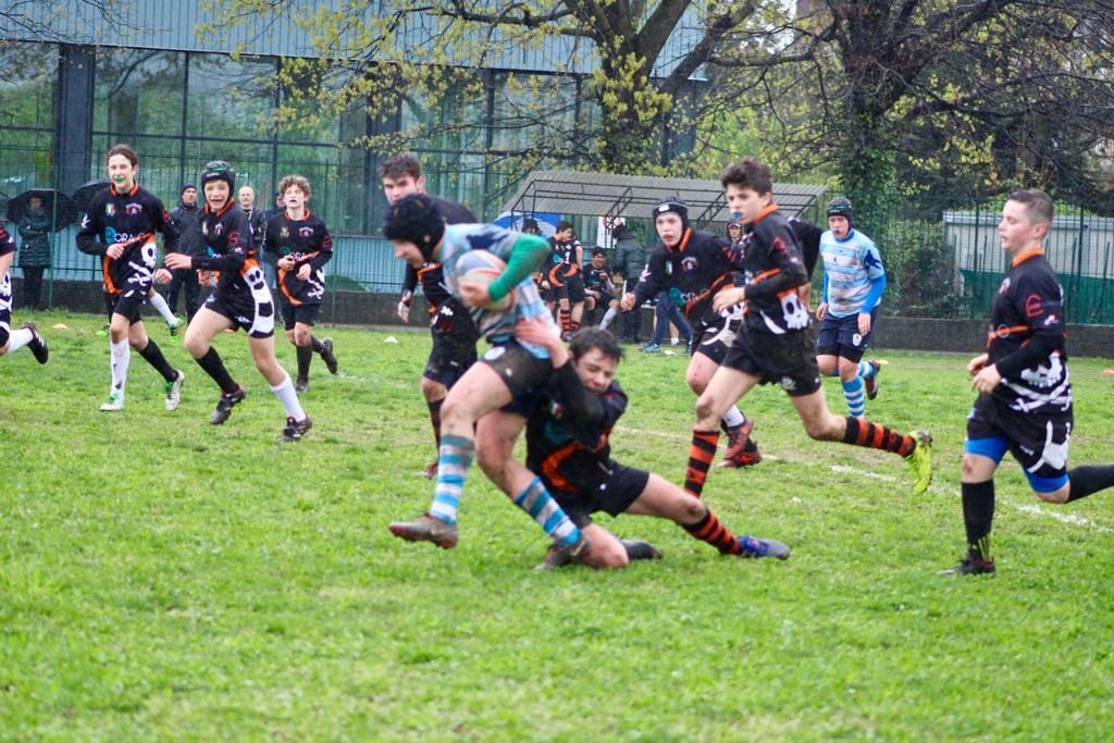 Un gruppo di giovani uomini sta giocando a rugby su un campo.