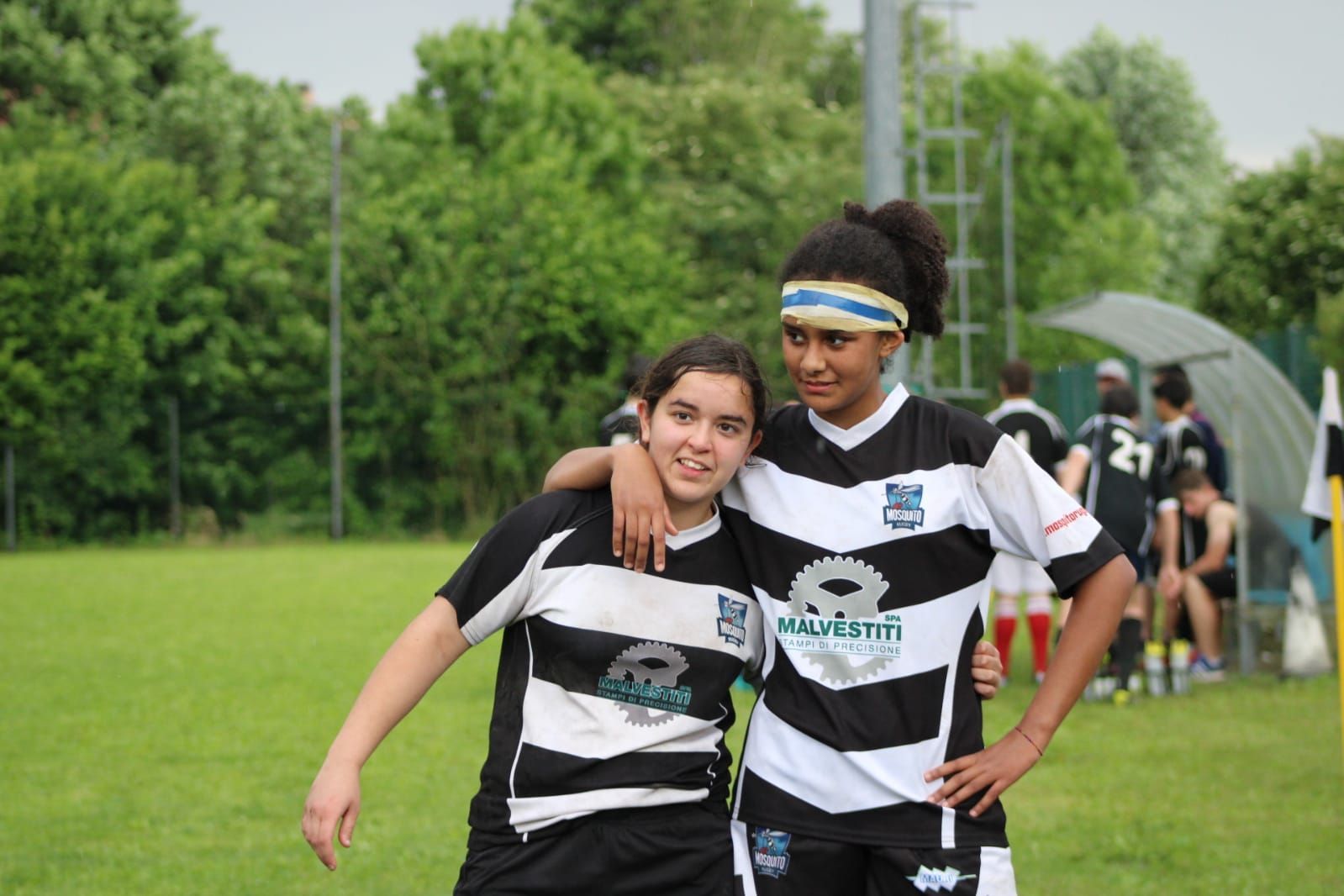 Due calciatrici posano per una foto su un campo.