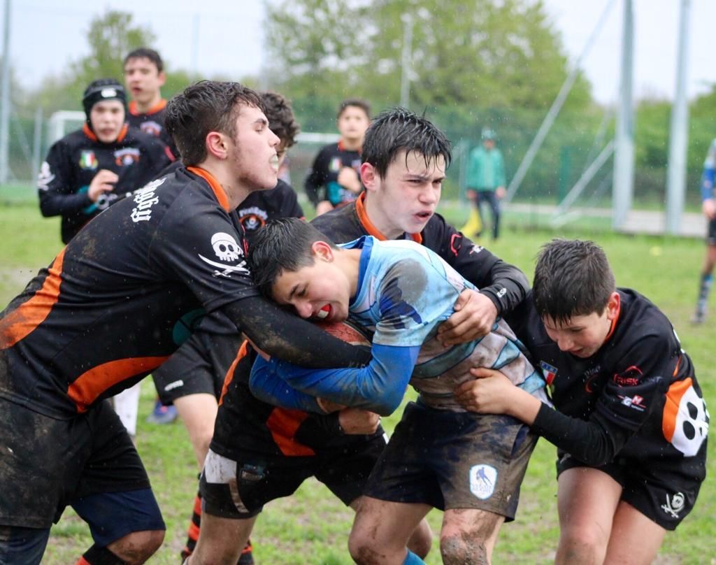 Un gruppo di giovani uomini sta giocando a rugby su un campo.