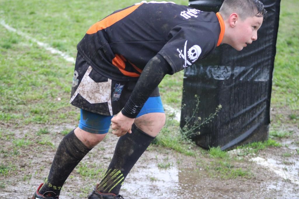 Un ragazzo che indossa una maglietta nera e arancione con un teschio e delle ossa incrociate sopra