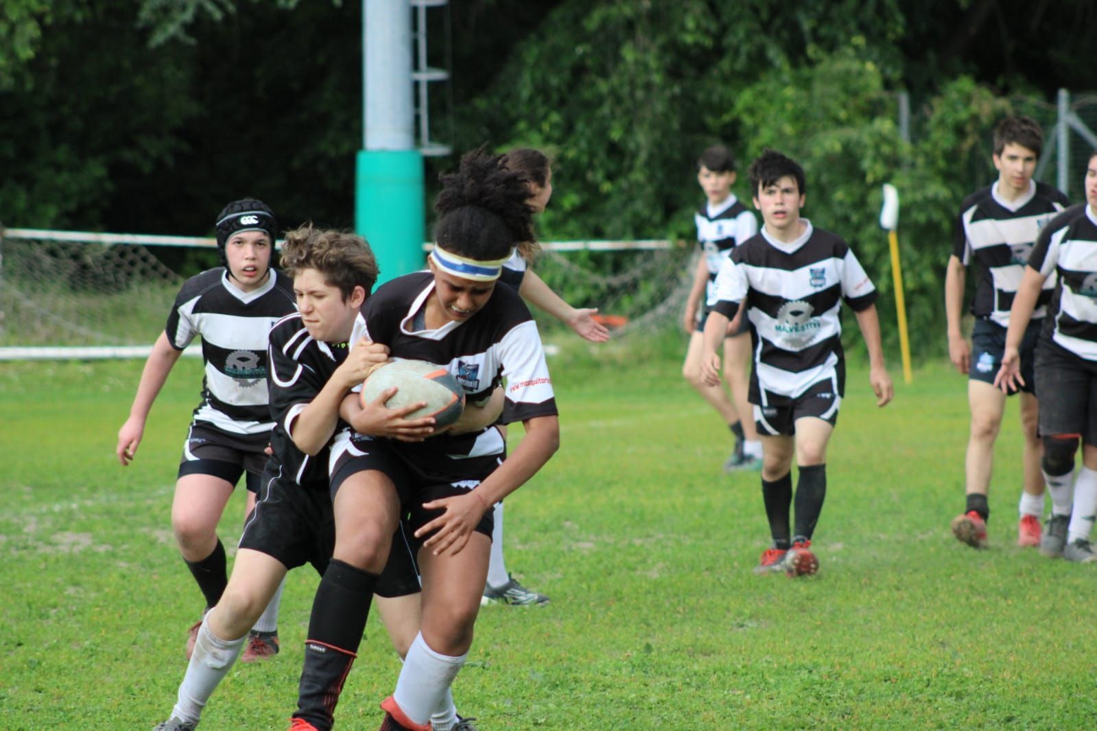 Un gruppo di ragazzi sta giocando a rugby su un campo.