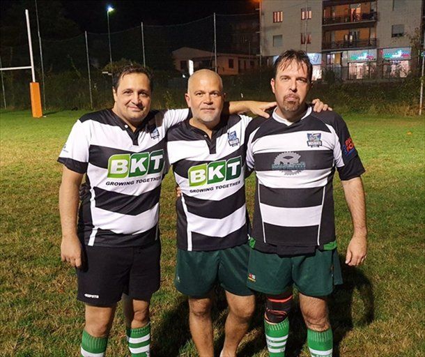 Tre uomini posano per una foto, uno dei quali indossa una maglietta con la scritta bkt