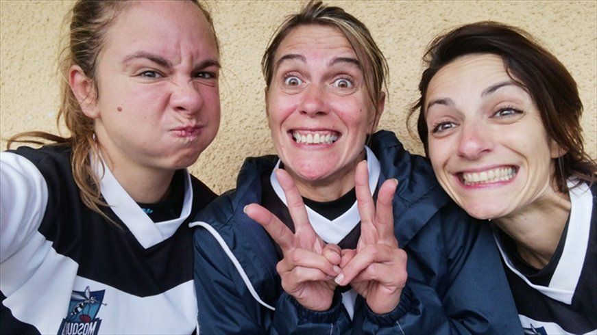 Tre donne posano per una foto e fanno facce buffe.