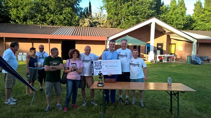 Un gruppo di persone in piedi attorno a un tavolo davanti a una casa