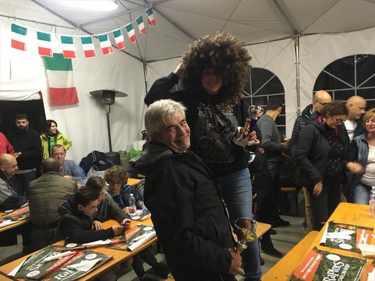 Un uomo tiene una donna sulle spalle in una stanza affollata