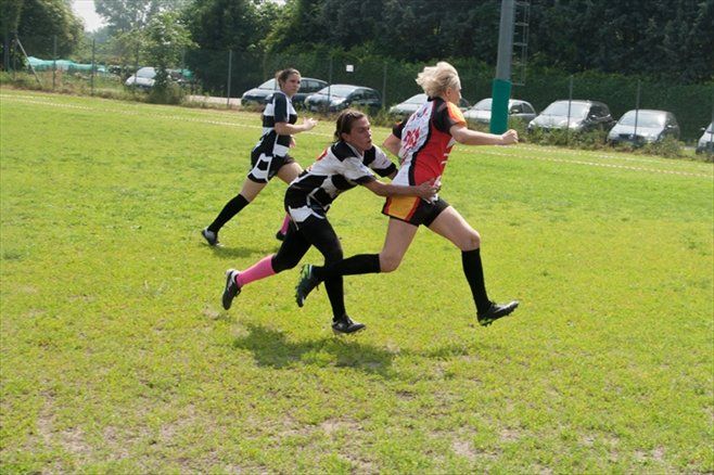 Un gruppo di donne sta giocando una partita di rugby su un campo.