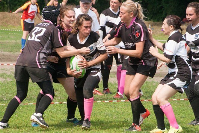 Un gruppo di giocatrici di rugby sta giocando una partita su un campo.