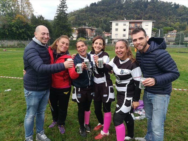 Un gruppo di persone in piedi in un campo che tengono in mano delle tazze