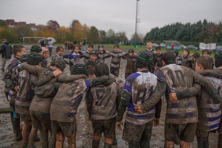 Un gruppo di ragazzi è ammassato insieme in un campo fangoso.