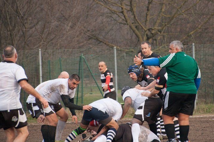 Un gruppo di uomini sta giocando una partita di rugby su un campo.