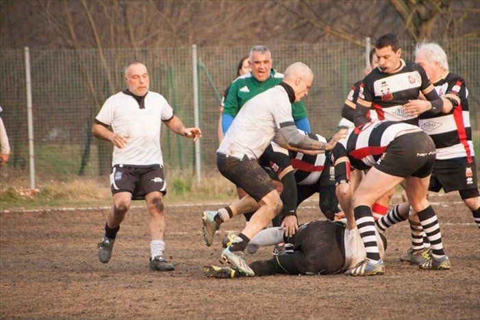 Un gruppo di uomini sta giocando una partita di rugby su un campo.