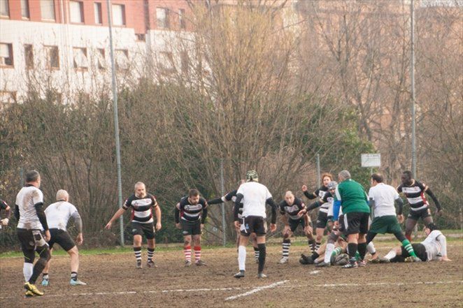 Un gruppo di uomini sta giocando una partita di rugby su un campo.