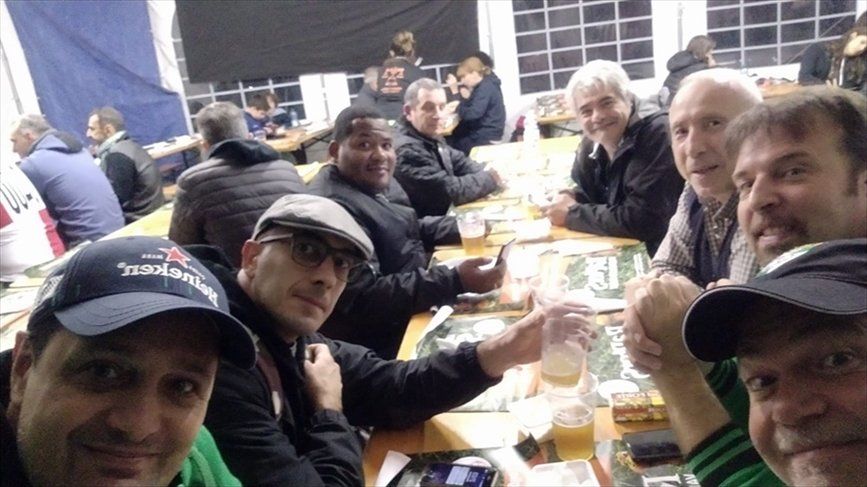 Un gruppo di uomini è seduto a un tavolo a bere birra