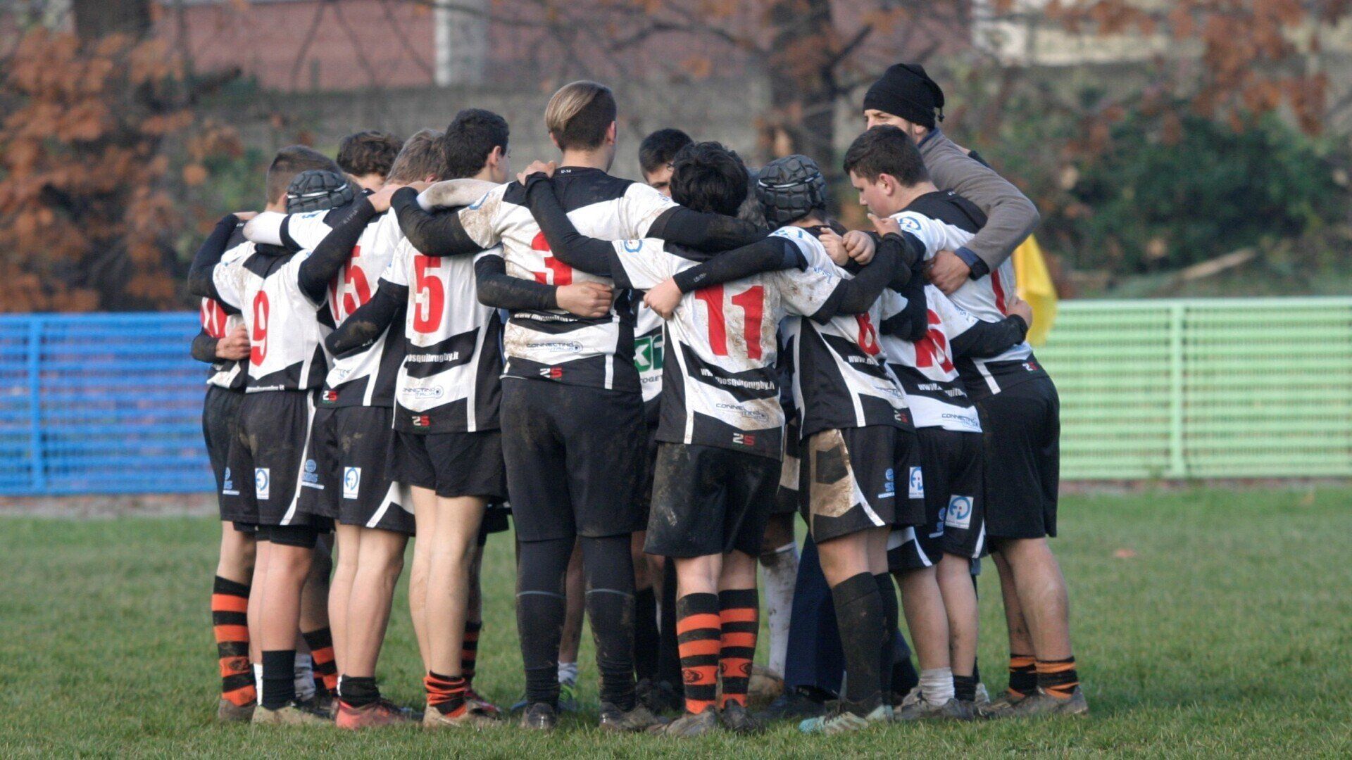 Un gruppo di giocatori di calcio è ammassato insieme su un campo.