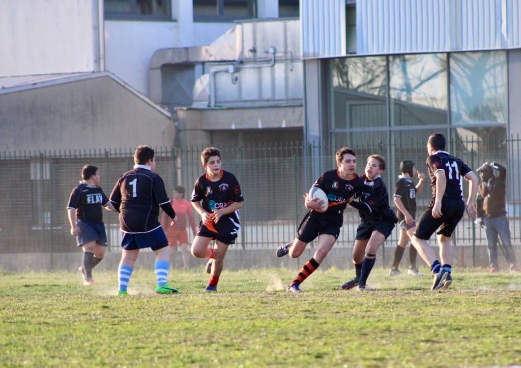 Un gruppo di giovani uomini sta giocando a rugby su un campo.