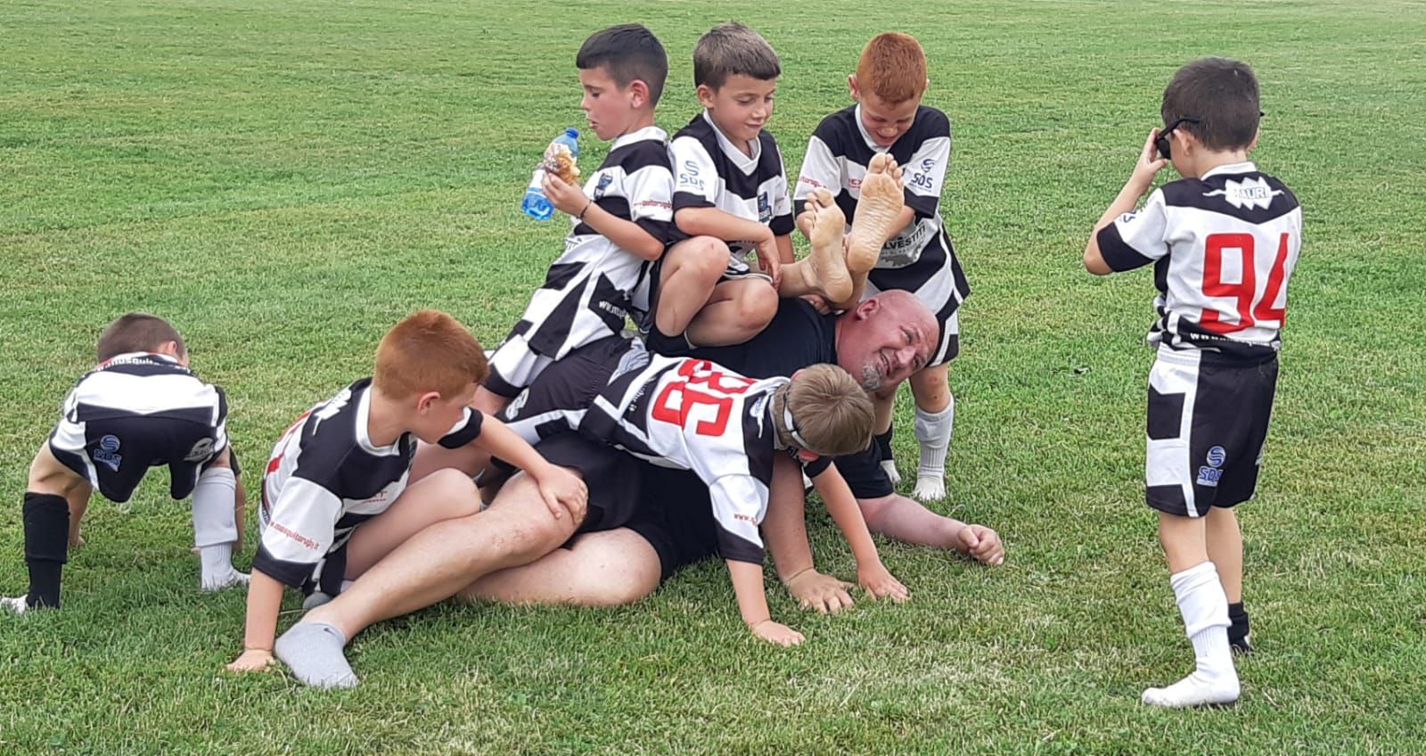 Un gruppo di ragazzi sta giocando a rugby su un campo.