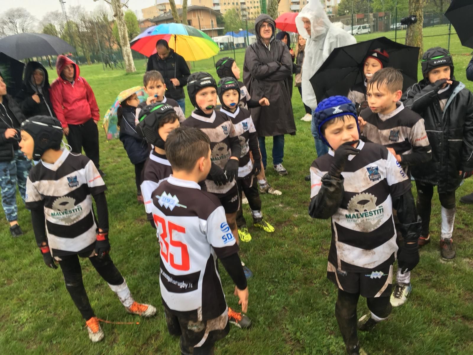 Un gruppo di ragazzi che indossano maglie a strisce bianche e nere con il numero 35 sul retro