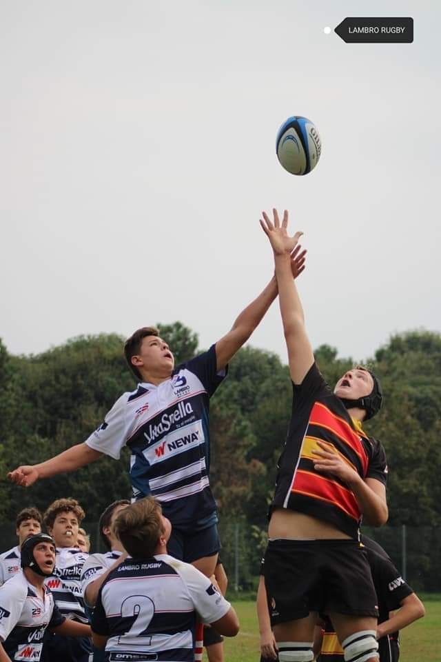 Un gruppo di giovani uomini sta giocando a rugby su un campo.