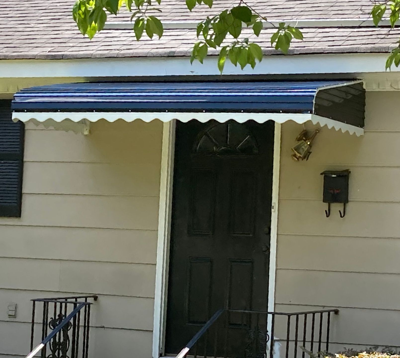 Black step down aluminum awning installed over door