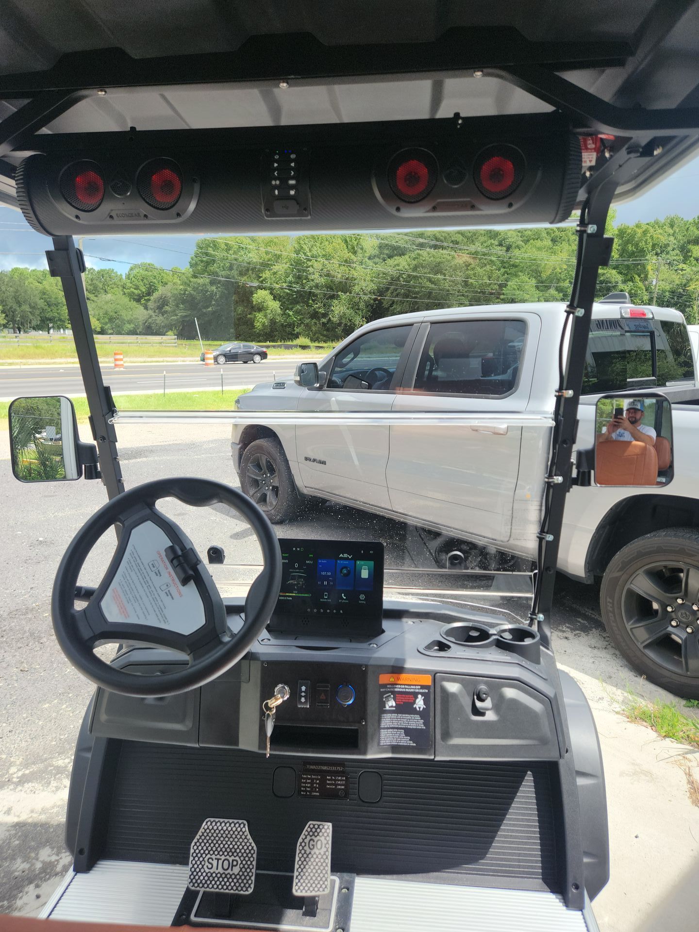 A golf cart is parked in a parking lot next to a truck.