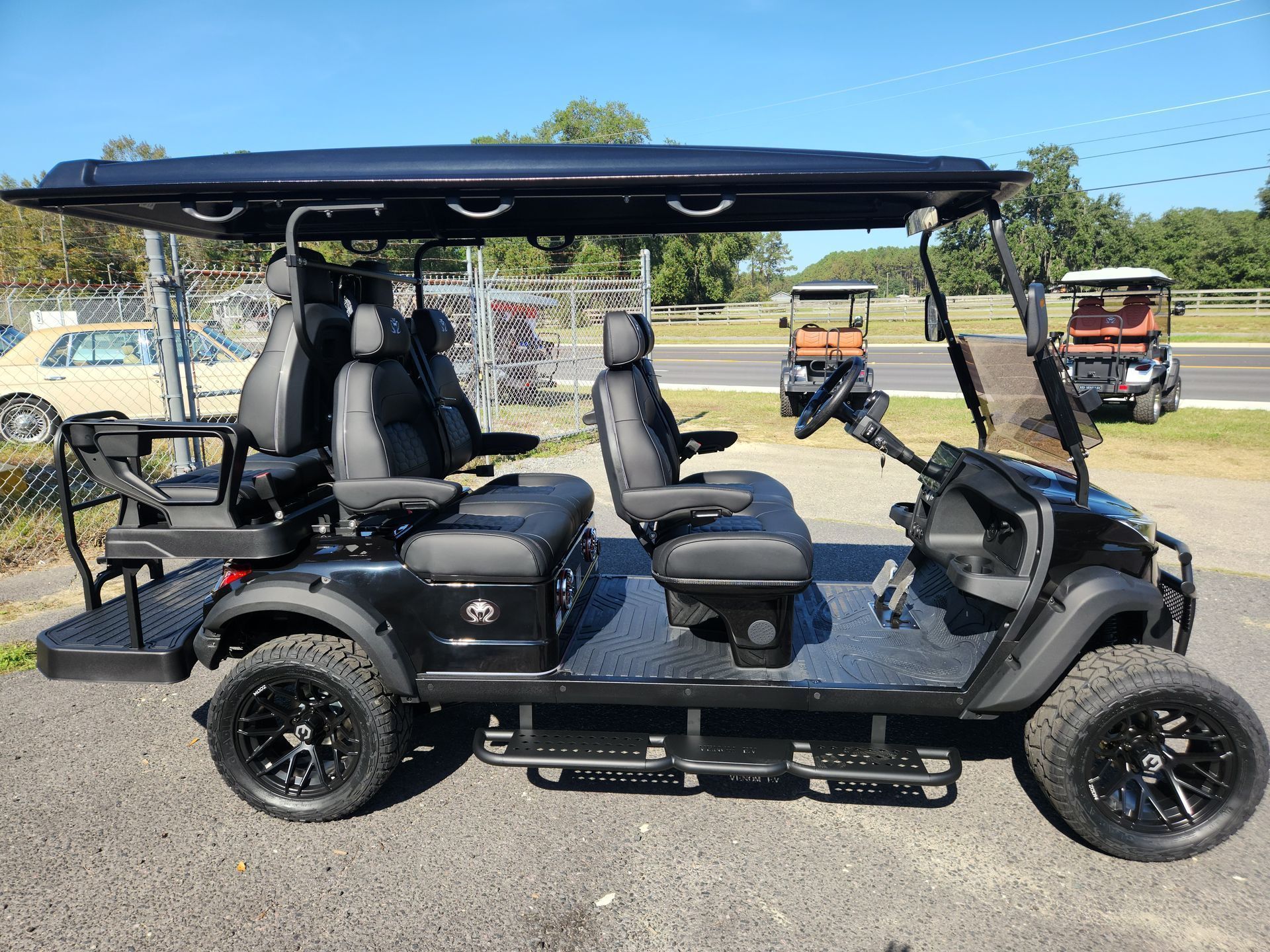 A black golf cart is parked on the side of the road.