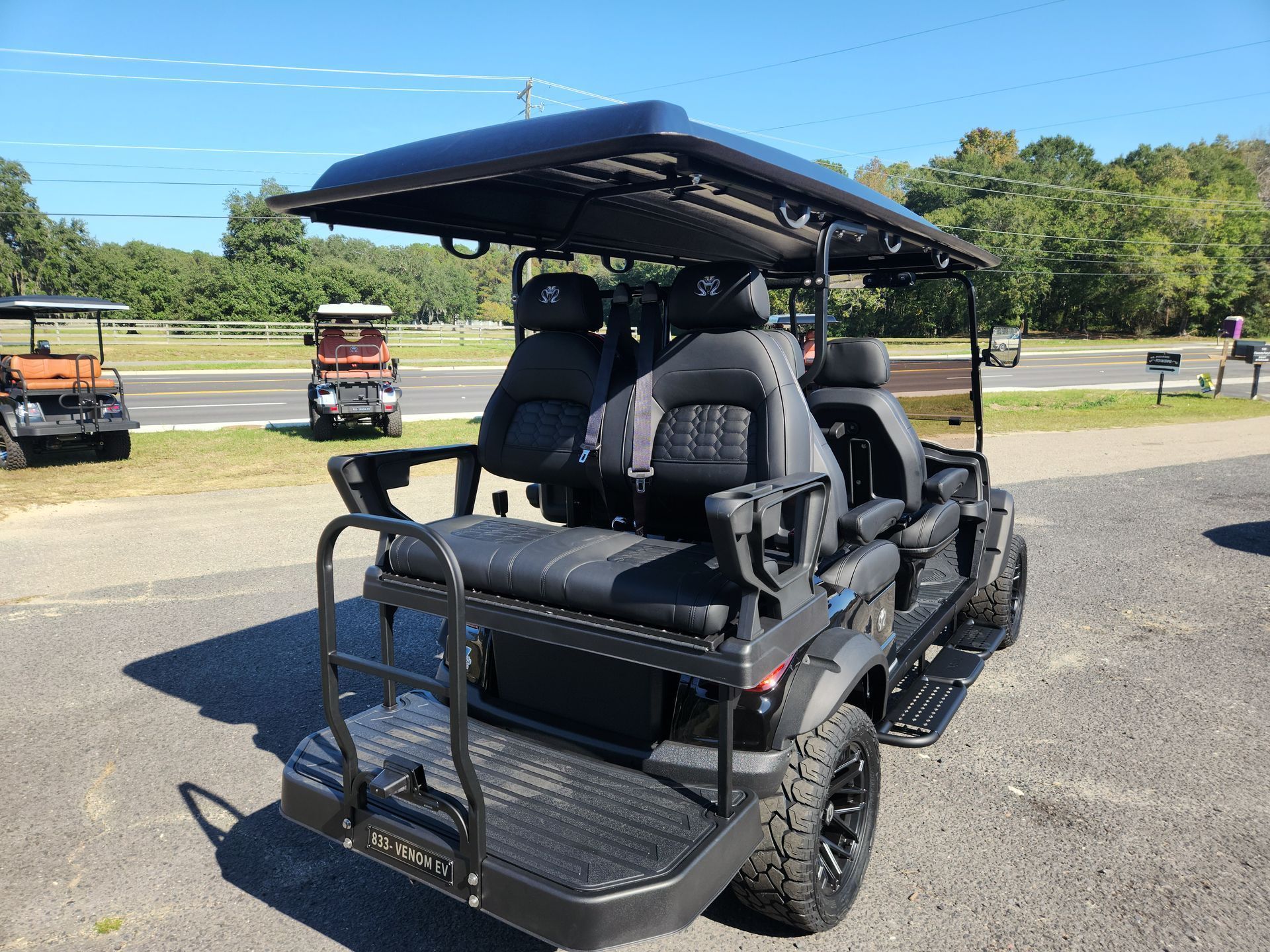 A black golf cart is parked on the side of the road.