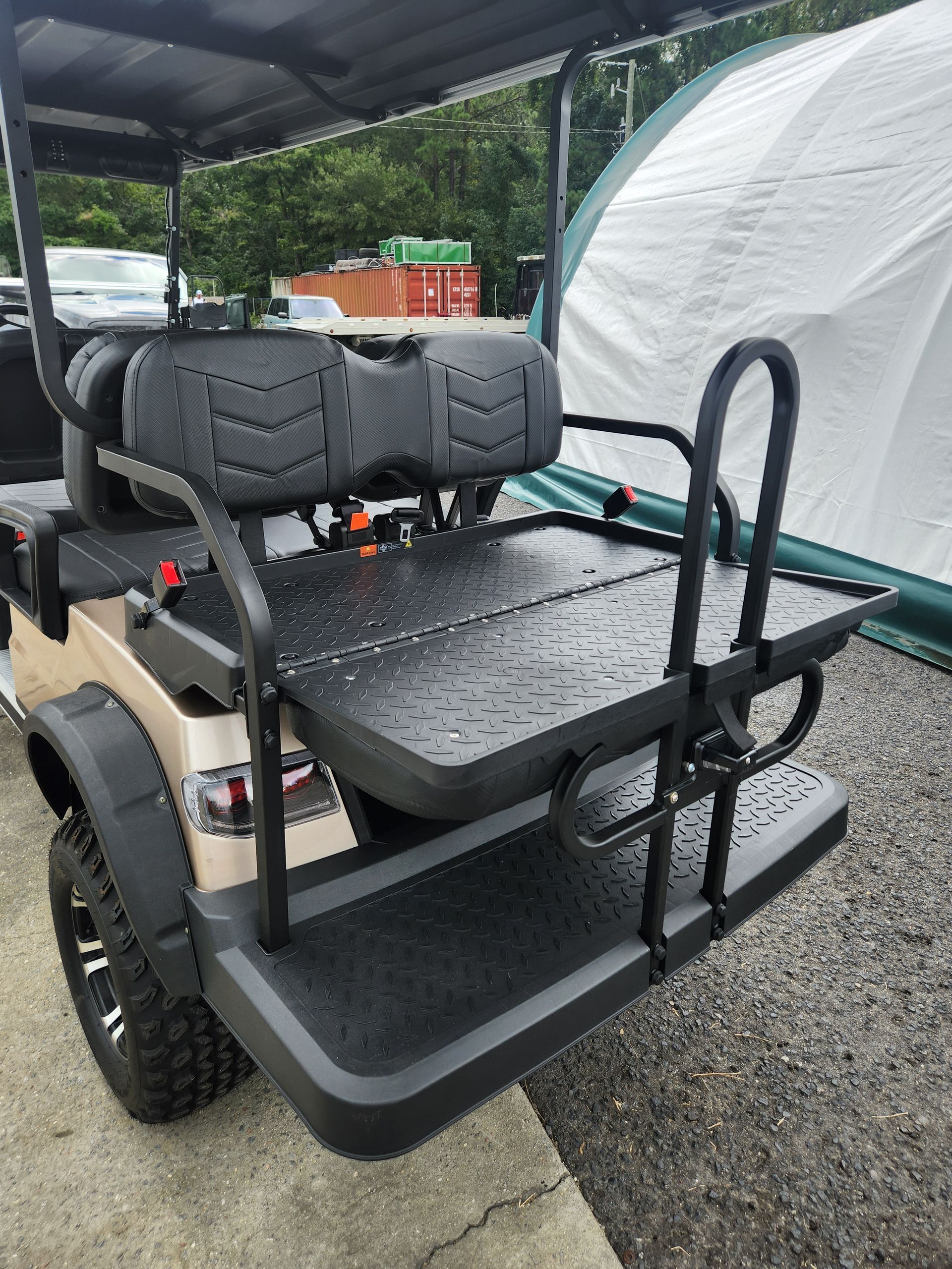 A golf cart is parked in front of a tent.