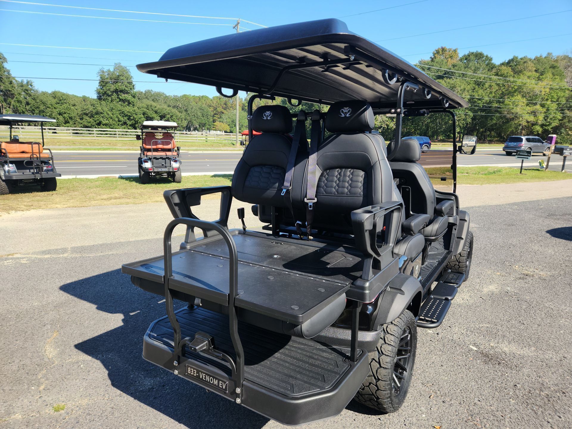 A black golf cart is parked on the side of the road.
