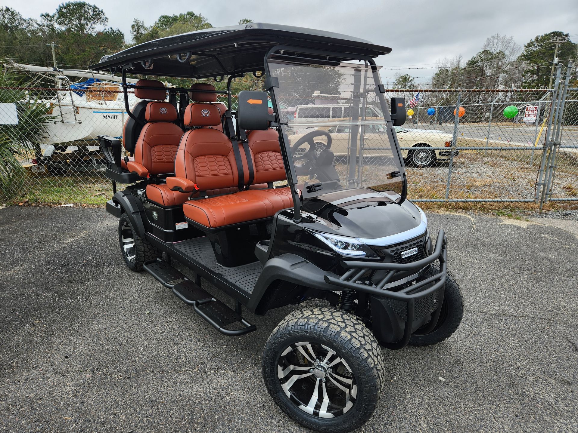 A white golf cart with red seats has been sold