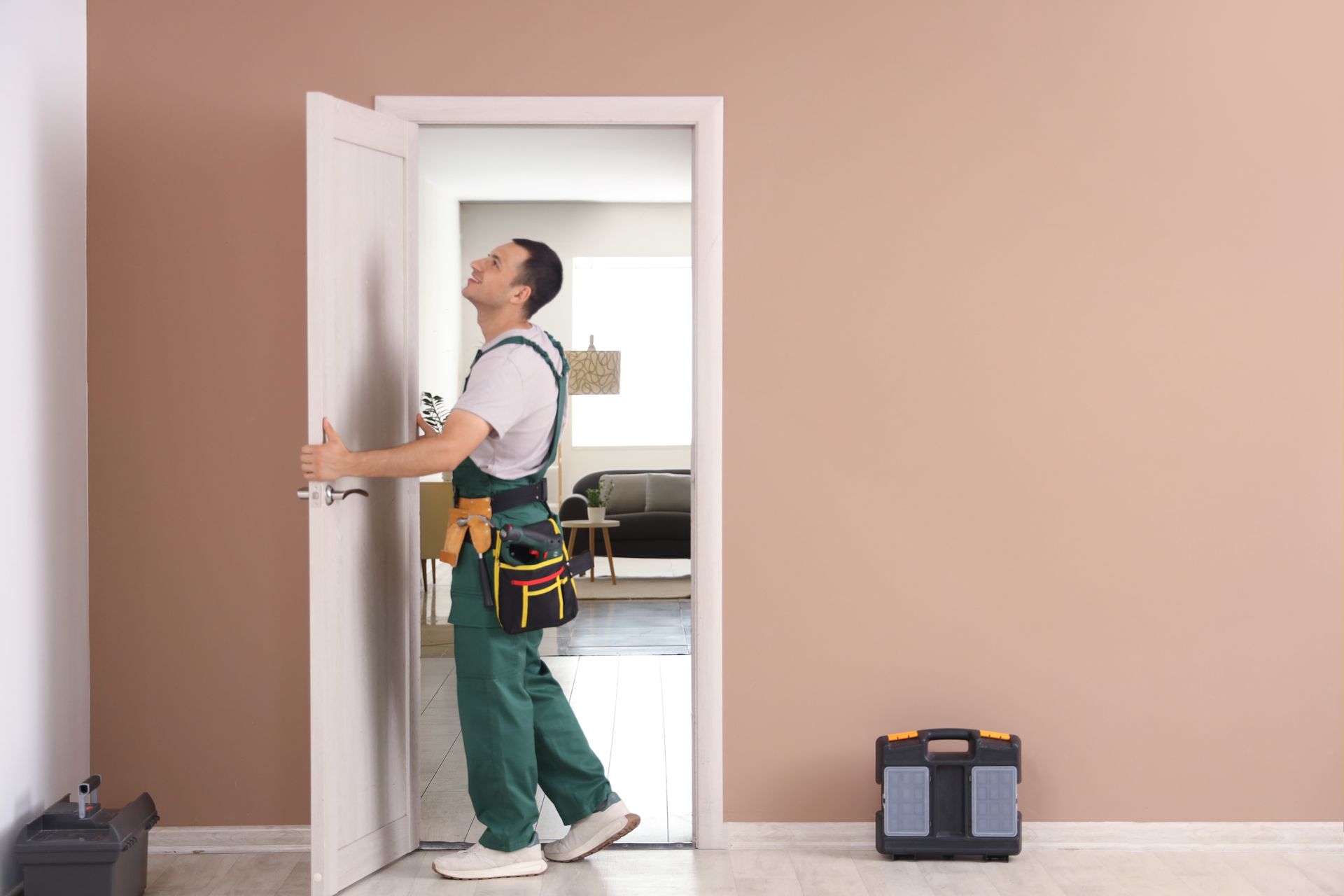 Handyman installing an interior door in a residential home with tools nearby and a clean workspace.