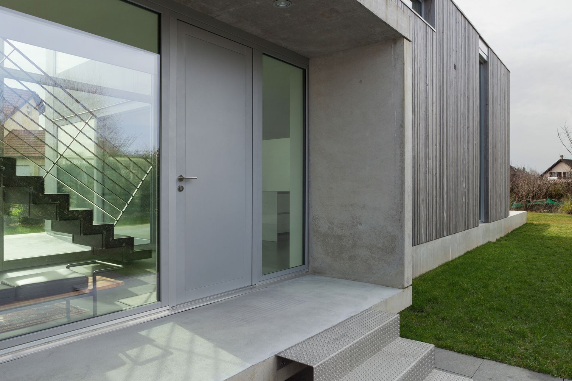 Modern house featuring a glass door and stairs, showcasing Thermalcraft’s elegant design. Ideal for 