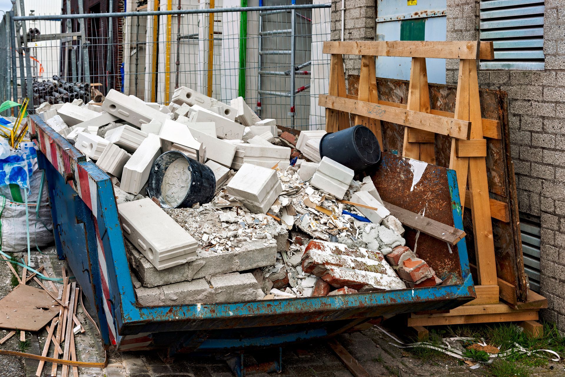 Construction debris-filled dumpster with bricks and other construction materials.