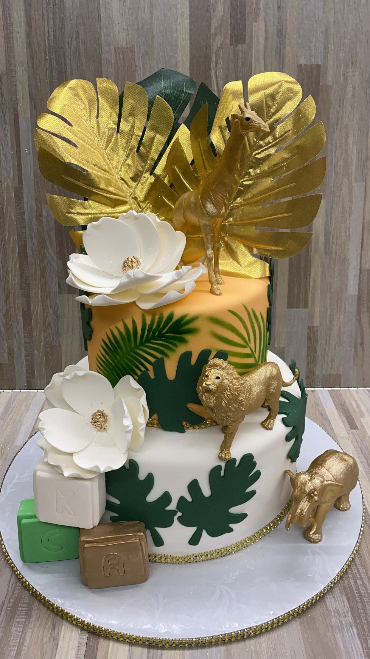 a cake with flowers and animals on it is sitting on a table .
