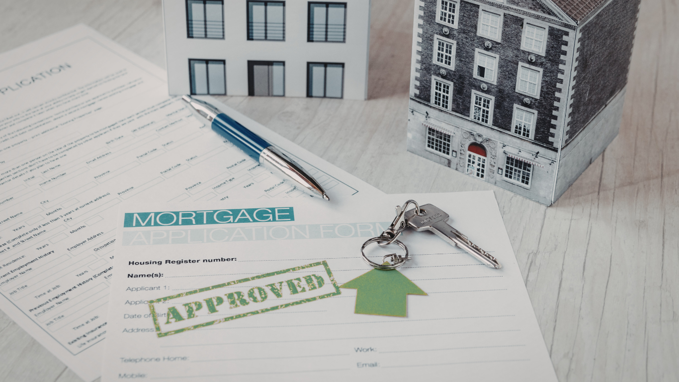 Mortgage approval documents with pen, keys, and miniature house models.