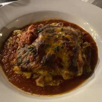 A close up of a plate of food with sauce on a table.