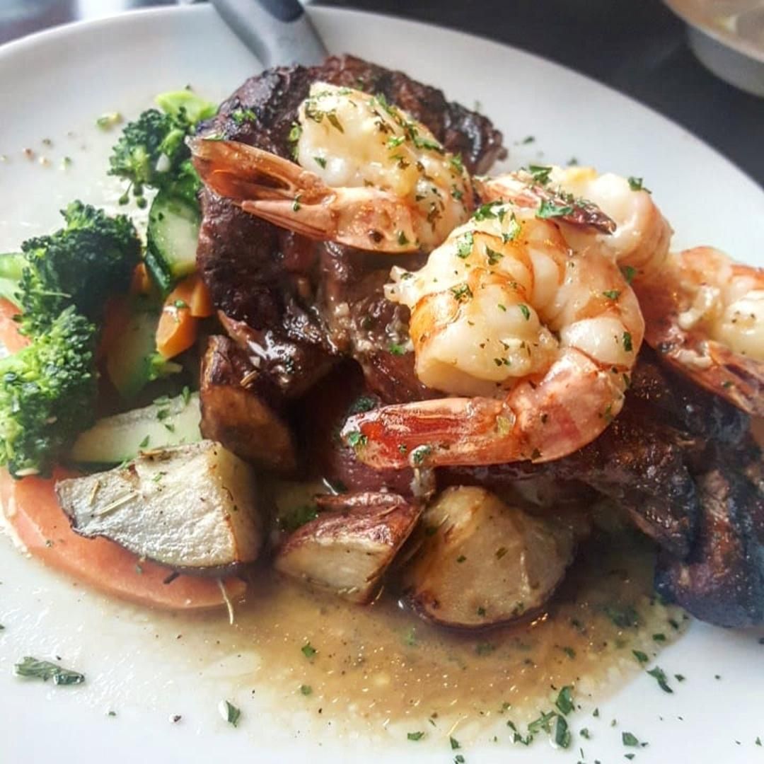 A close up of a plate of food with shrimp and broccoli