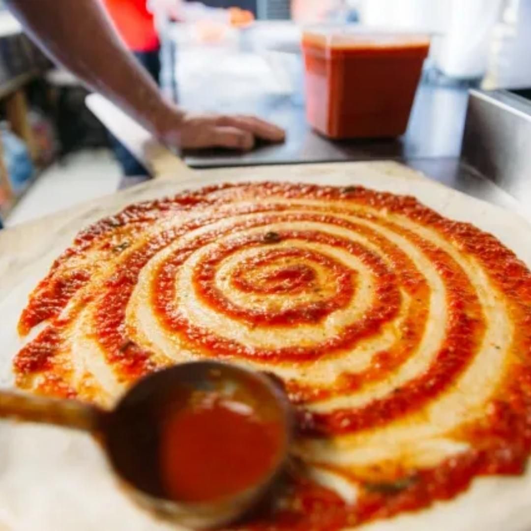 A pizza with a swirl of sauce on it