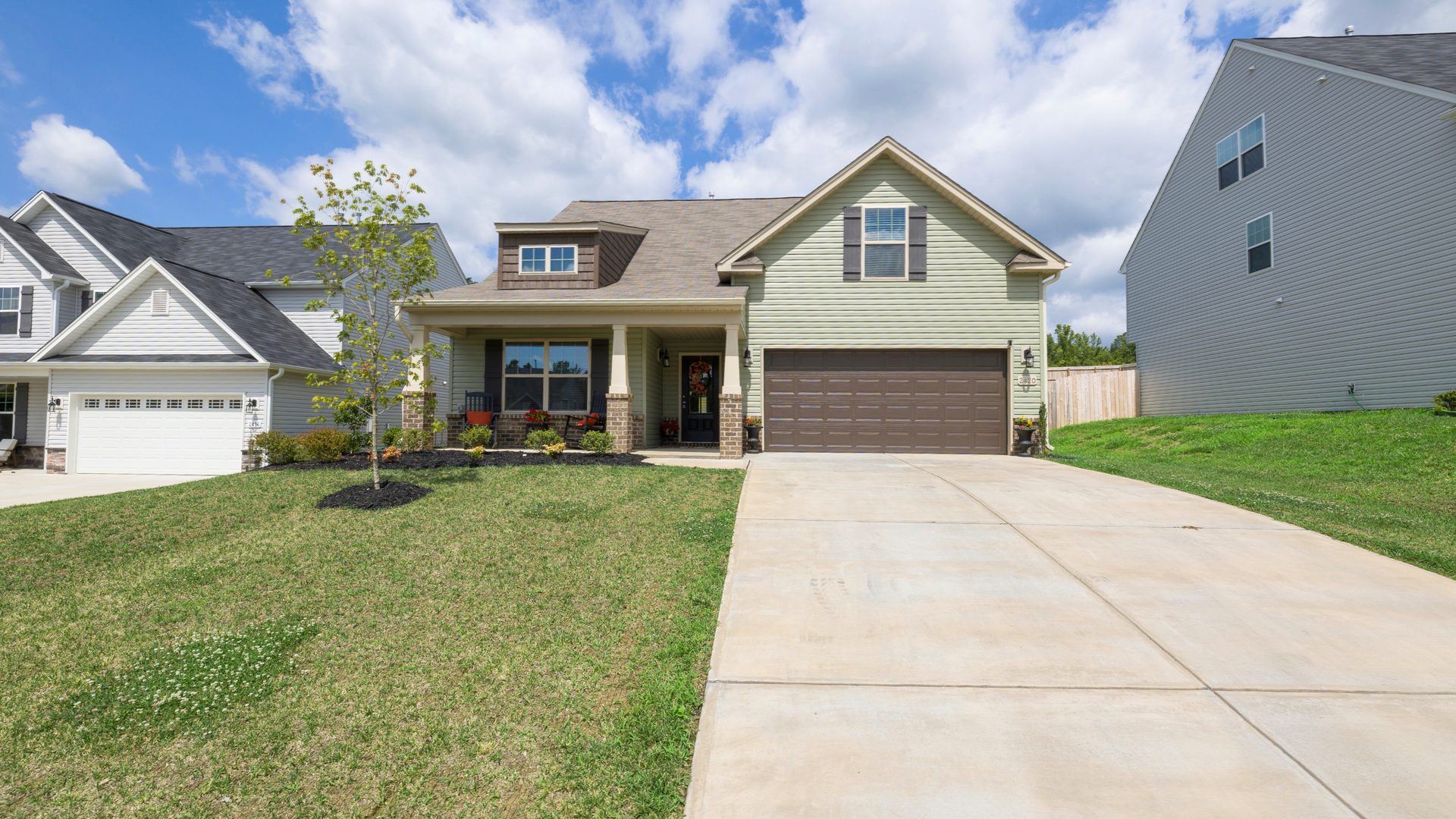Modern suburban home with a wide, broom-finished concrete driveway and two-car garage.