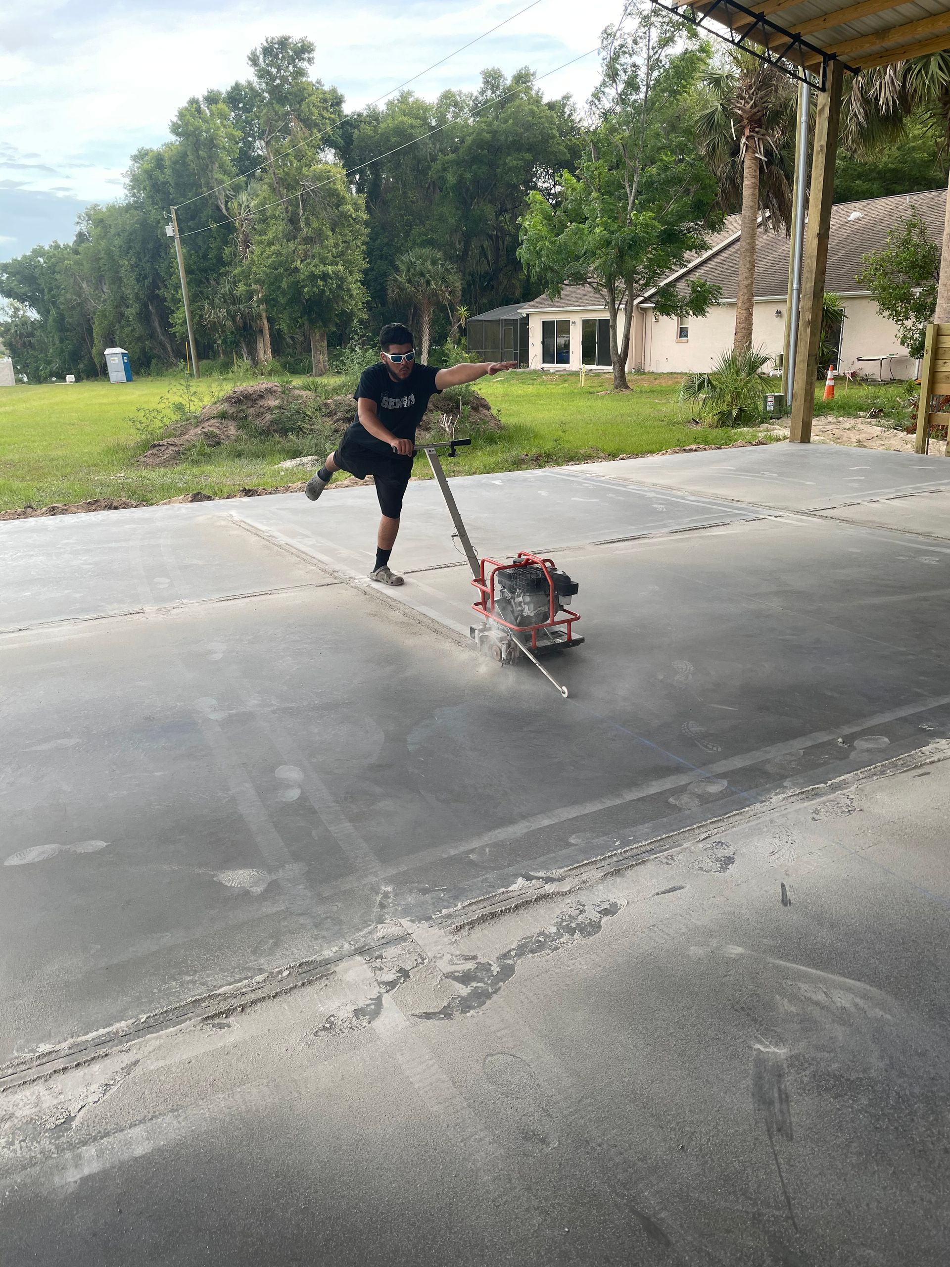 A man is using a machine to level a driveway.