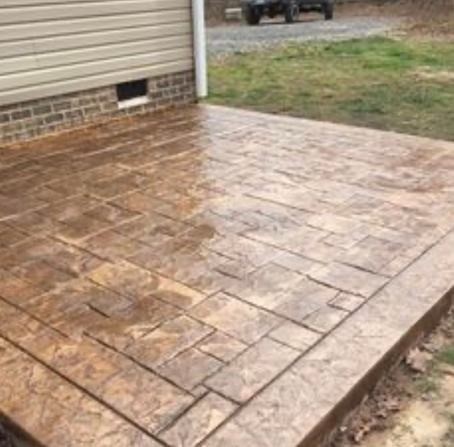 A stamped concrete patio with a couch and chairs under a pergola. Project done by C1 Foundations in Ocala FL
