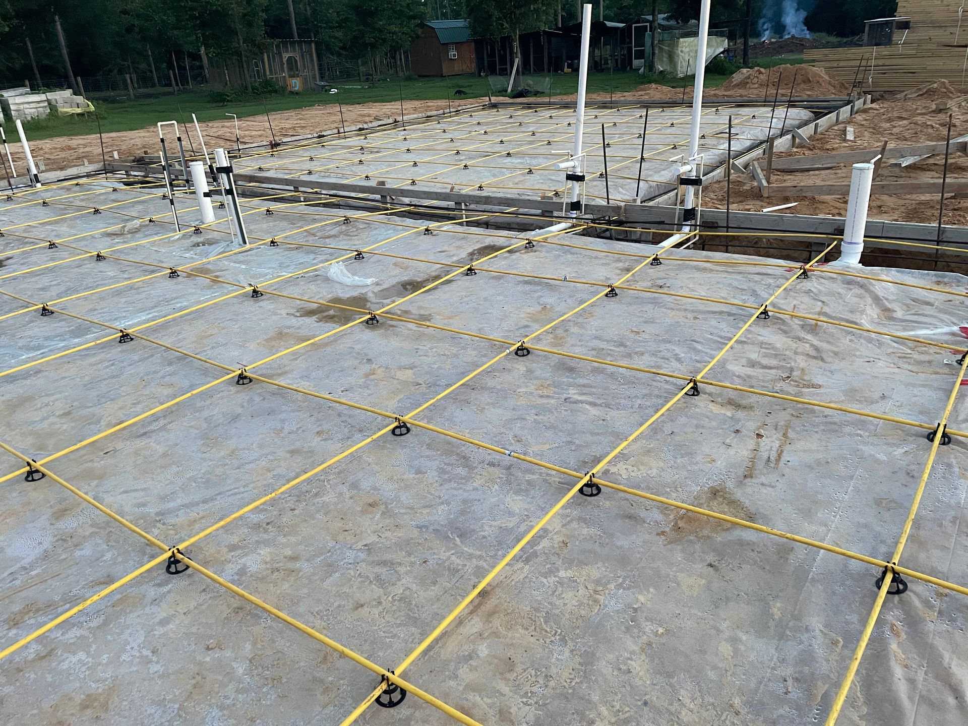 A concrete floor with yellow lines on it is being built.