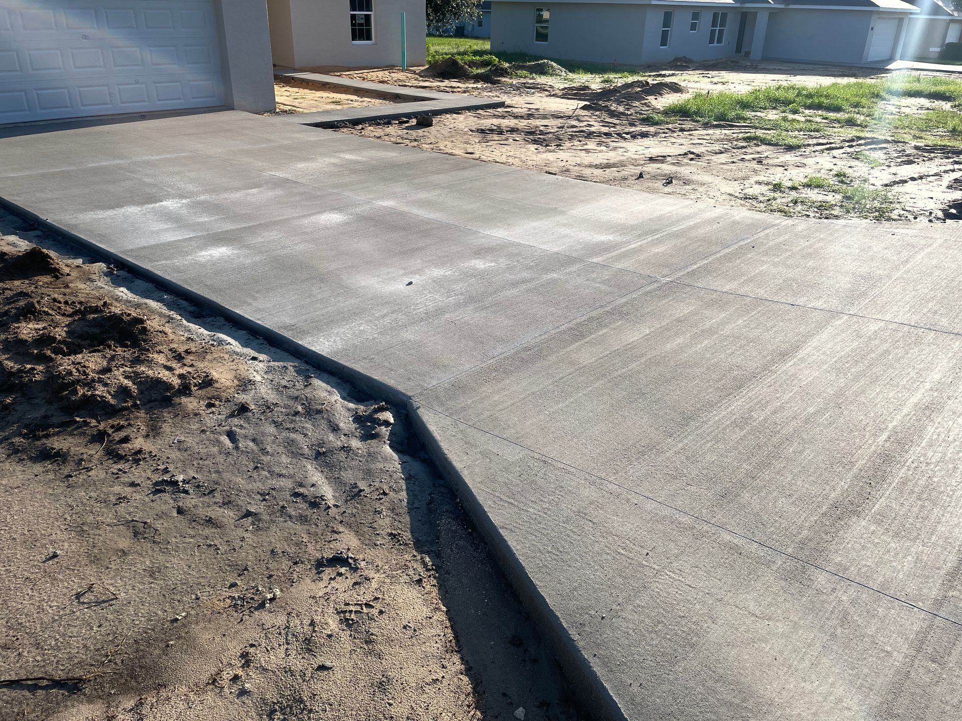 A concrete driveway is being built in front of a house.