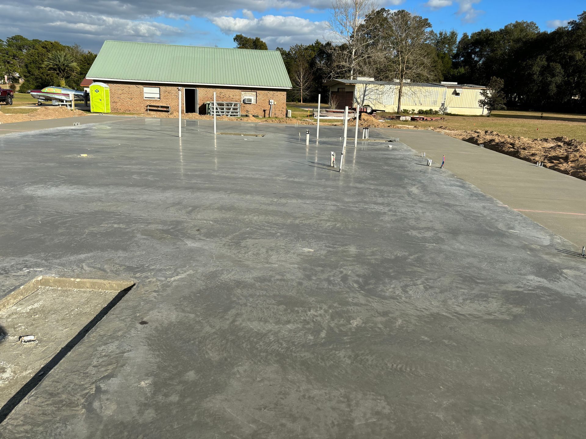 A concrete driveway with a house in the background