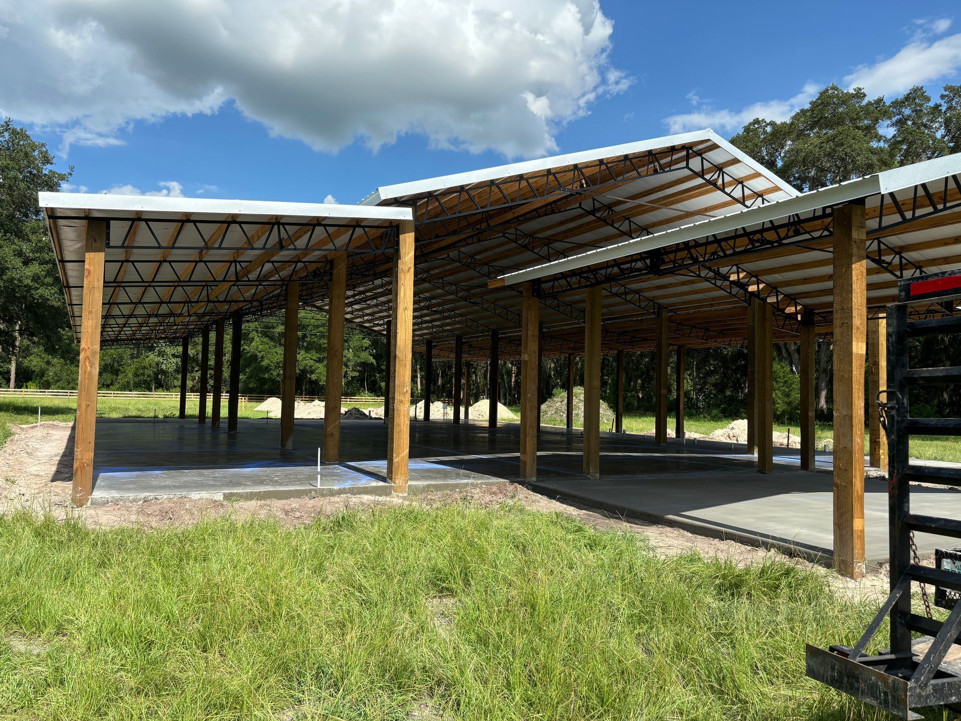 A large building is being built in the middle of a grassy field.
