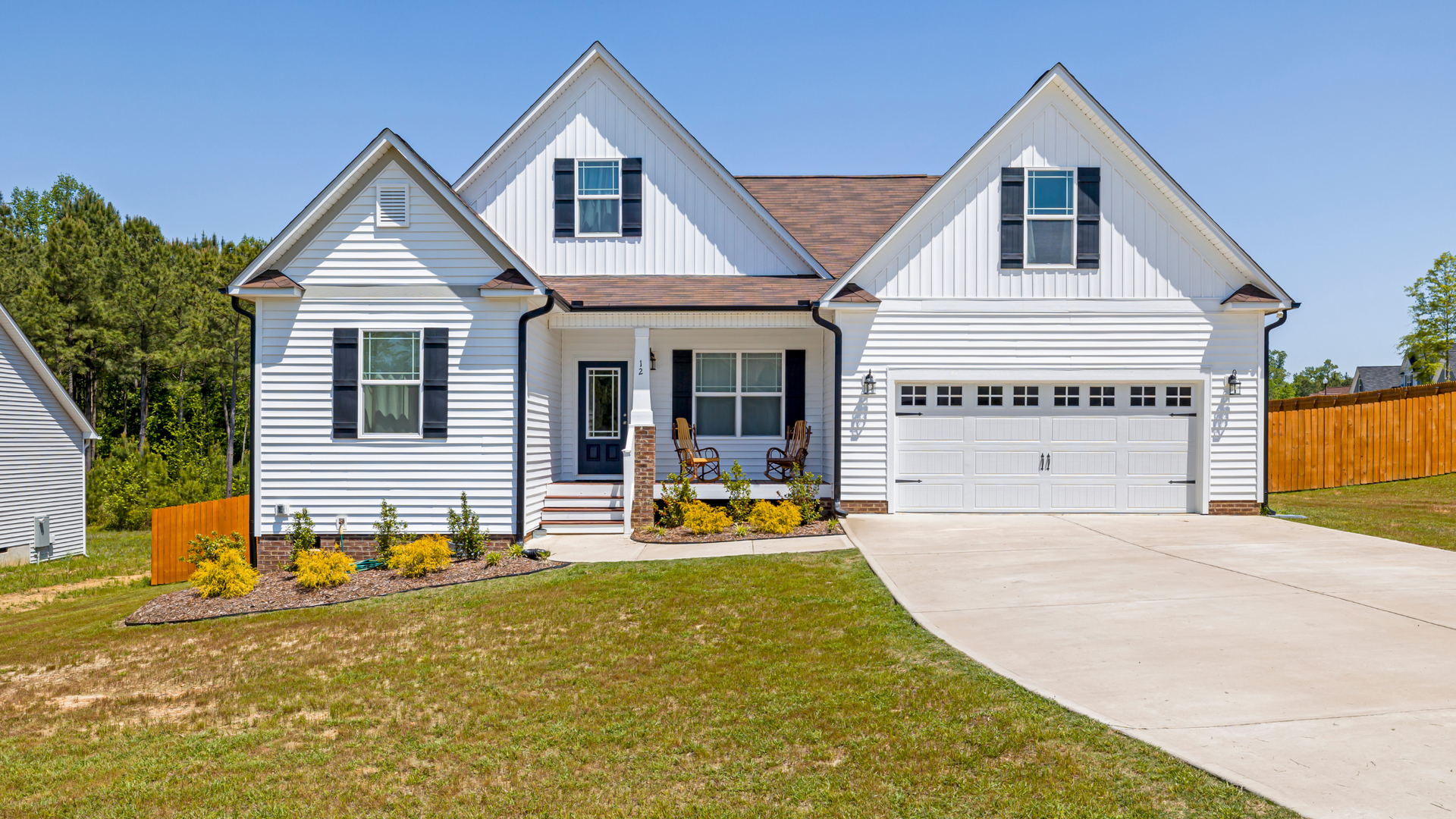 Fresh concrete driveway installation in front of a white vinyl siding home in Ocala, Florida.
