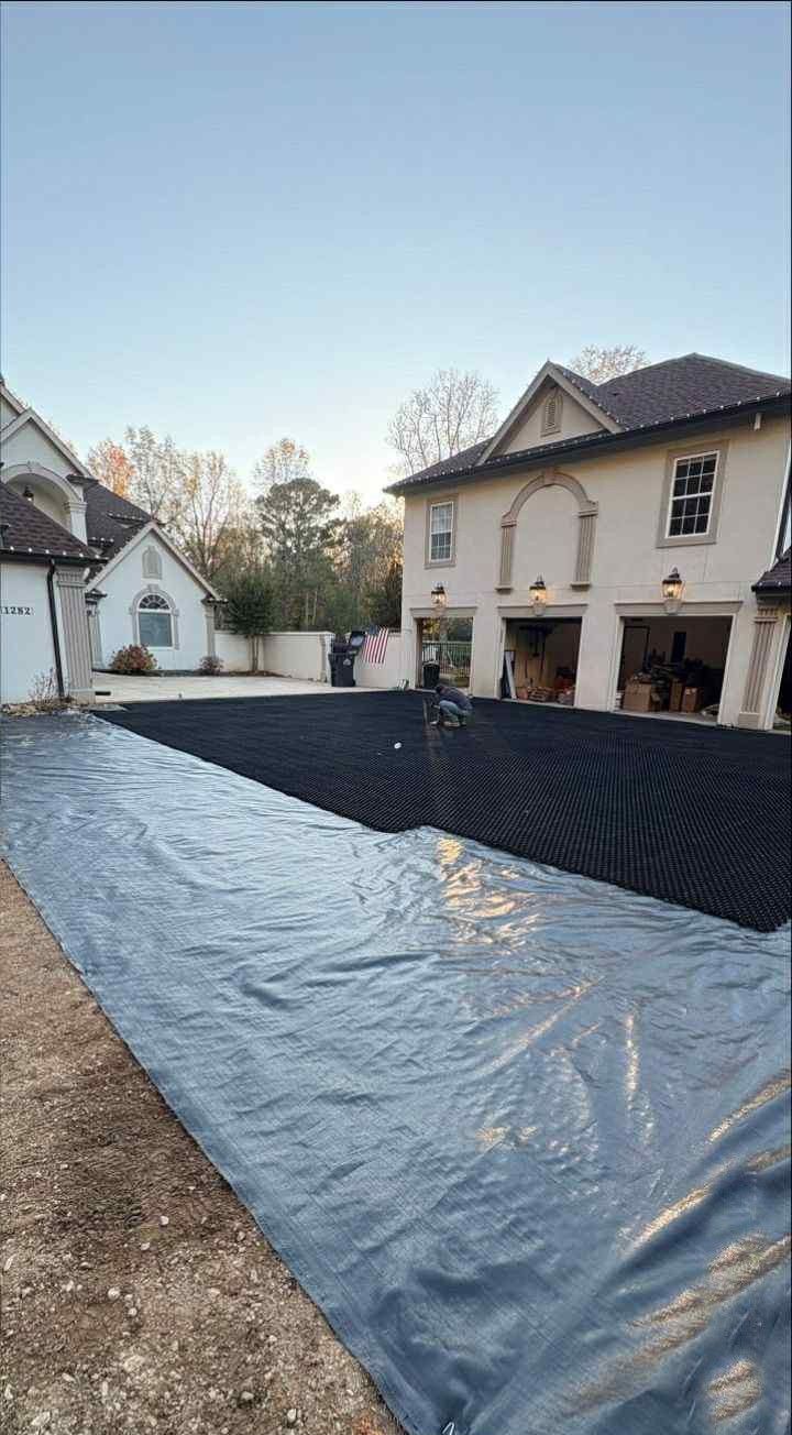Residential courtyard with a large black tarp-covered pool under construction between houses