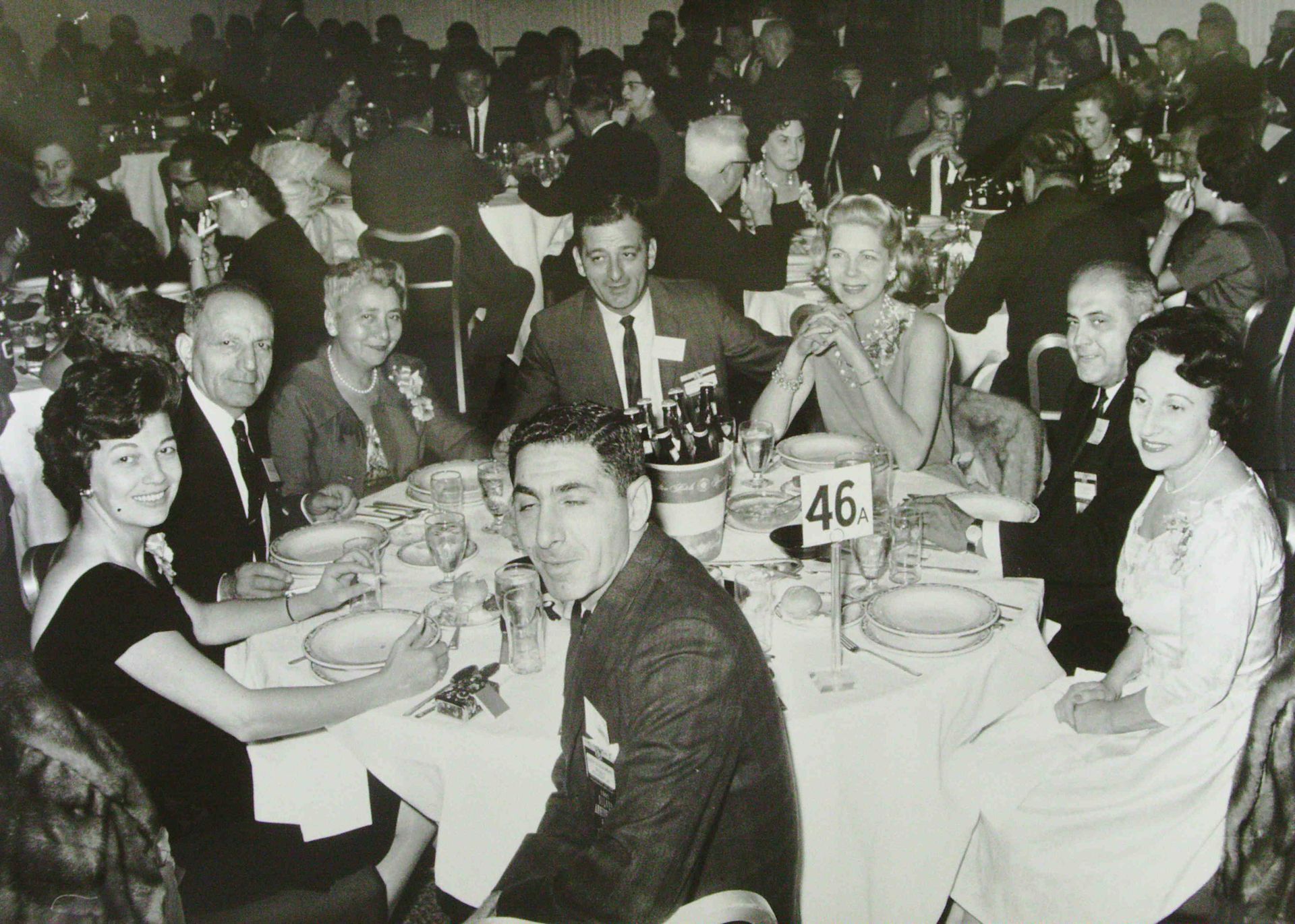 A group of people are sitting around a table with a number 46 on it