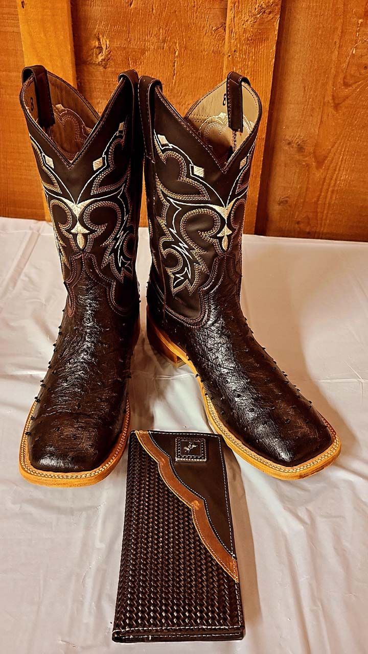 A pair of cowboy boots and a wallet are sitting on a table.