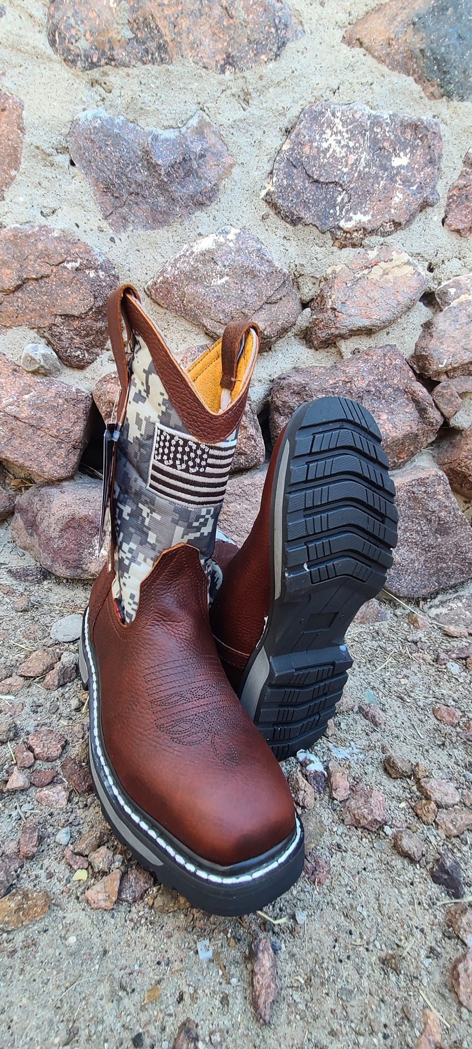 A pair of brown boots are laying on the ground.