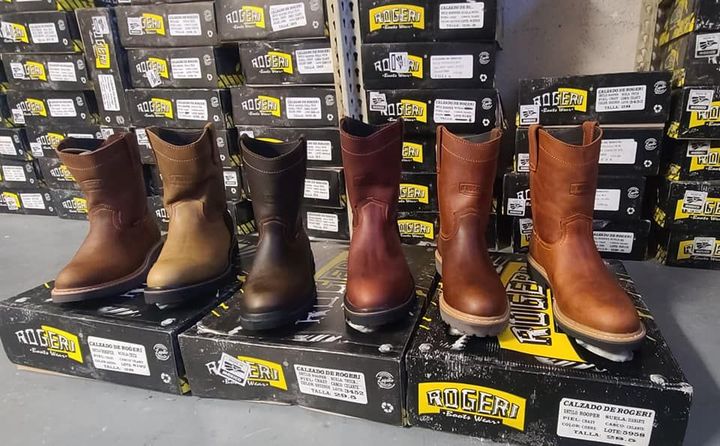 A row of cowboy boots sitting on top of boxes